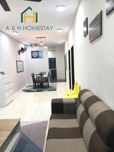 A&H Homestay Teluk Intan في تيلوك إنتان: غرفة معيشة مع أريكة وطاولة