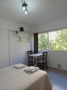 um quarto com uma cama, uma mesa e uma janela em Hermoso monoambiente en ciudad de Mendoza. em Mendoza