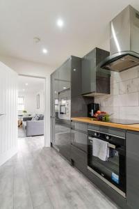 cocina con electrodomésticos de acero inoxidable y sala de estar. en Bridge Court by Sterling Edge Apartments - Luxury Aparthotel - Stylish 1-bed Apartments - Balcony with Canal View or Private Garden - Free Parking en Birmingham