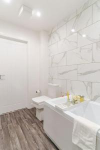 a white bathroom with a sink and a toilet at Bridge Court by Sterling Edge Apartments - Luxury Aparthotel - Stylish 1-bed Apartments - Balcony with Canal View or Private Garden - Free Parking in Birmingham