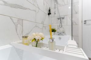 baño con paredes de mármol blanco y lavabo en Bridge Court by Sterling Edge Apartments - Luxury Aparthotel - Stylish 1-bed Apartments - Balcony with Canal View or Private Garden - Free Parking, en Birmingham