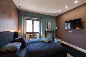 a bedroom with a bed and a tv on the wall at Ma Maison in Pian Nava