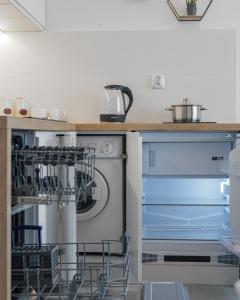 a dishwasher in a kitchen next to a counter at Reymonta 23 B - 5 min Metro - 15 min Centrum - 10 min CMKP in Warsaw +8 photos