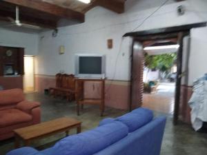 a living room with a blue couch and a tv at Casa en Pochutla de adobe con boveda catalana in San Pedro Pochutla