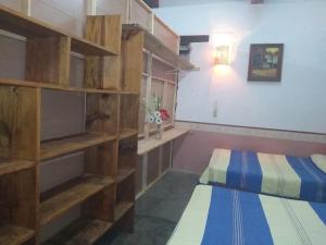 a bedroom with two beds and wooden shelves at Casa en Pochutla de adobe con boveda catalana in San Pedro Pochutla