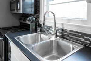 a stainless steel sink in a kitchen with a window at Cheerful Family Home - 3 mins drive to UWindsor in Windsor
