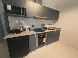 una cucina con armadi grigi e piano di lavoro di Departamento tipo loft! a Villa Zorraquín Altre 10 foto