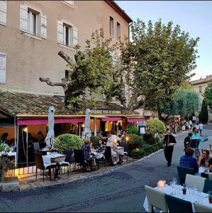 un grupo de personas sentadas en las mesas fuera de un restaurante en Suite Bastide Magdaleyna Mougins, en Mougins
