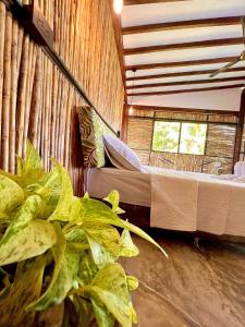 a room with a bed and a plant in it at Finca en Doradal ( Hacienda Napoles y Rio Claro ) in Doradal