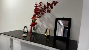 a table with a vase of flowers and a mirror at Apartamento cerca al centro y sitios turísticos in Bogotá