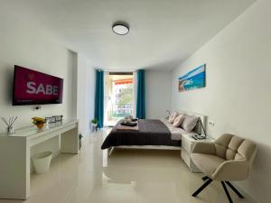 a bedroom with a bed and a chair and a desk at Royal View Apartment - Los Cristianos in Los Cristianos