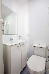 Un baño blanco con inodoro y lavabo. en Cortijo EL CHAMAN LOS ESCULLOS, en Almería 19 fotos más