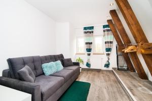 a living room with a gray couch and a green rug at Arkadia Kadyny in Kadyny