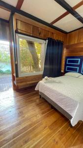 sypialnia z łóżkiem i dużym oknem w obiekcie Mayan Spirit w mieście Flores