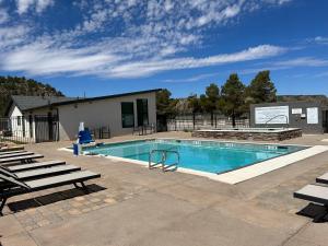 a swimming pool with chairs and a building at Unique 2 Bedroom Campsite on the backside of Zion in Apple Valley