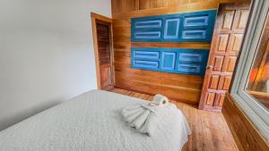 - une chambre avec un lit et un mur en bois dans l'établissement Mayan Spirit, à Flores
