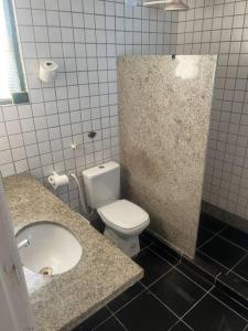 ein Badezimmer mit einem weißen WC und einem Waschbecken in der Unterkunft Casa Beira Mar Barra Sirinhaem in Sirinhaém