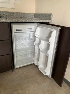 un frigorifero vuoto con la porta aperta in una cucina di Stay and Dive a Cuajiniquil