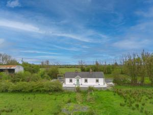 una casa blanca en medio de un campo en Teachin milis Moineir en Boyle