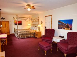 a hotel room with a bed and two chairs at AmeriVu Inn & Suites - St Croix Falls in Saint Croix Falls