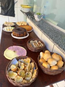 una mesa cubierta con cestas de pan y bollería en Pousada Sol e Mar en Morro de São Paulo