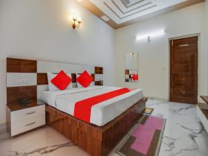 a bedroom with a large bed with red pillows at OYO Hotel Yellow Stone in Patiāla