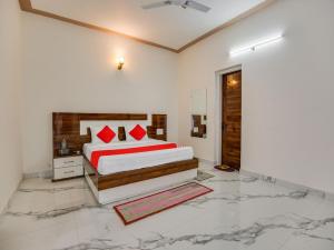a bedroom with a bed with red pillows on it at OYO Hotel Yellow Stone in Patiāla