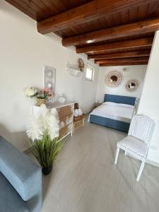 a bedroom with a bed and a couch and chairs at Sunset Brucoli in Brucoli