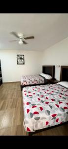 a bedroom with two beds and a ceiling fan at Hotel del Alba Inn & Suites in Aguascalientes