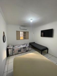 a living room with a bed and a flat screen tv at Apto 3 otimo Local próximo Shopping in Campo Grande