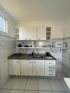 a white kitchen with white cabinets and a sink at Apto 3 otimo Local próximo Shopping in Campo Grande