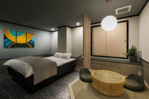 een slaapkamer met een bed, een tafel en een raam bij Hotel Ritmo & Gessy ラブホテル in Fukuoka