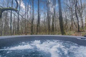 a hot tub in the middle of a forest at Padley; woodland lodge with hot tub for 2-4 in the Staffordshire Moorlands in Oakamoor