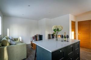 a living room with a couch and a table with flowers at Padley; woodland lodge with hot tub for 2-4 in the Staffordshire Moorlands in Oakamoor