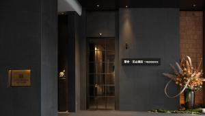 un ingresso a un edificio con porta a vetri di Phoenix Hall House Hotel a Fenghuang