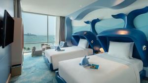 Habitación de hotel con 2 camas con temática de delfines en Holiday Inn Pattaya, an IHG Hotel en Pattaya centro