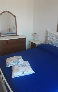 una camera con letto blu e specchio di Villa Diana a Capoliveri