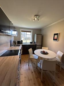 eine Küche mit einem Tisch, einem Tisch und Stühlen in der Unterkunft Reykjavik Urban Escape 2-Bedroom Haven with Private Entrance in Reykjavík