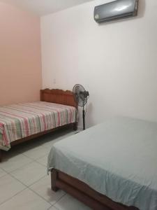a room with two beds and a fan at Stay Tapachula in La Concepción