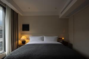 Un dormitorio con una cama grande y una ventana en Phoenix Hall House Hotel, en Fenghuang