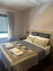 a bedroom with a large bed with towels on it at aerOPOrto Guesthouse in Maia