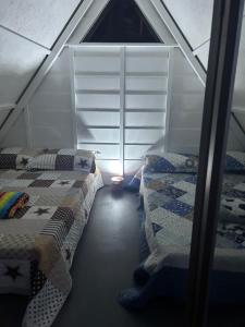 a attic room with two beds and a window at Glamping La Mardo in Cartago