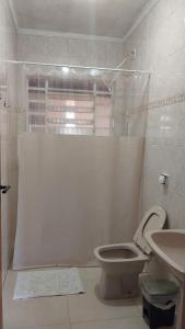 bagno bianco con servizi igienici e lavandino di Casa com linda Vista no Centro a Serra Negra