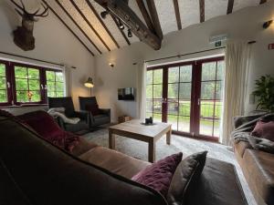 een woonkamer met een bank en een tafel bij Ardennes villa with riverside garden and views in Atzerath