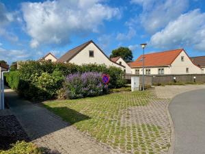 een huis met een tuin met bloemen en struiken bij Cozy fisherman's house with garden in Koksijde