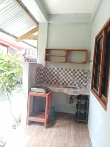 a kitchen with a sink and a table in a room at Bearby Homestay Siargao - K2 in Catangnan