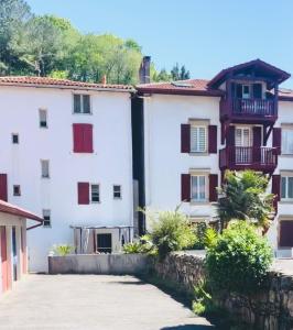 un edificio blanco con balcones y un patio en Élégant 2 chambres à deux pas de l'Espagne, en Urrugne