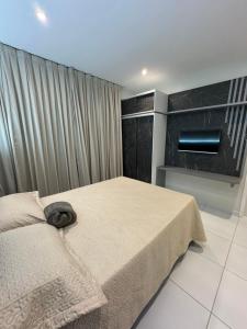 1 dormitorio con cama y cortina grande en Apartamento localizado em condomínio fechad0 em Barra Grande - PI, en Parnaíba