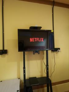 a tv on a stand with a netflix sign on it at Permata Beach Chalet in Kampong Juara