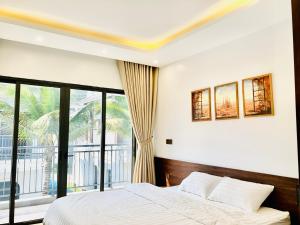 - une chambre avec un lit et une grande fenêtre dans l'établissement V3E02 Dahlia villa - khu nghỉ dưỡng Sonasea Vân Đồn, à Cái Rồng